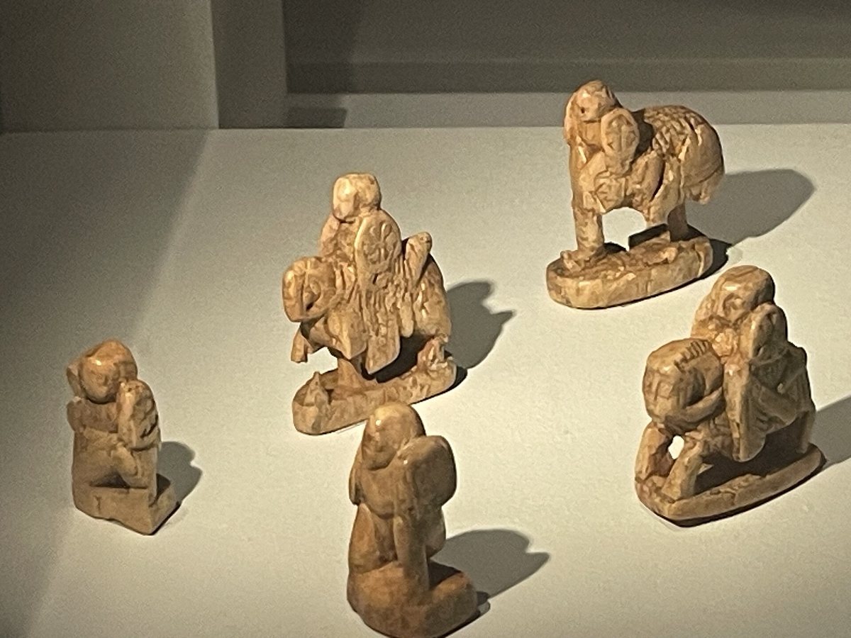 博物館のケースに並ぶ、古い時代の小さな彫刻のチェスの駒