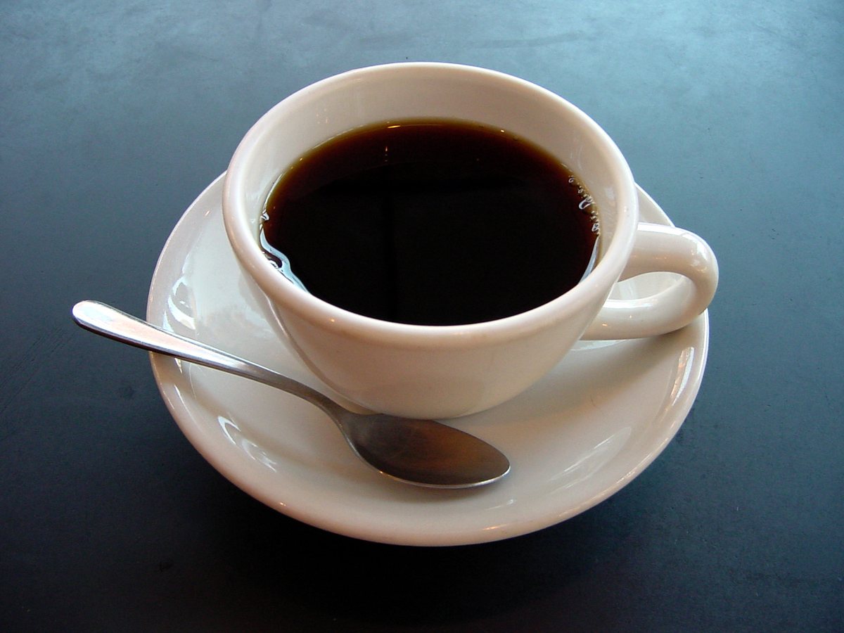 白いカップに入ったブラックコーヒーとスプーン