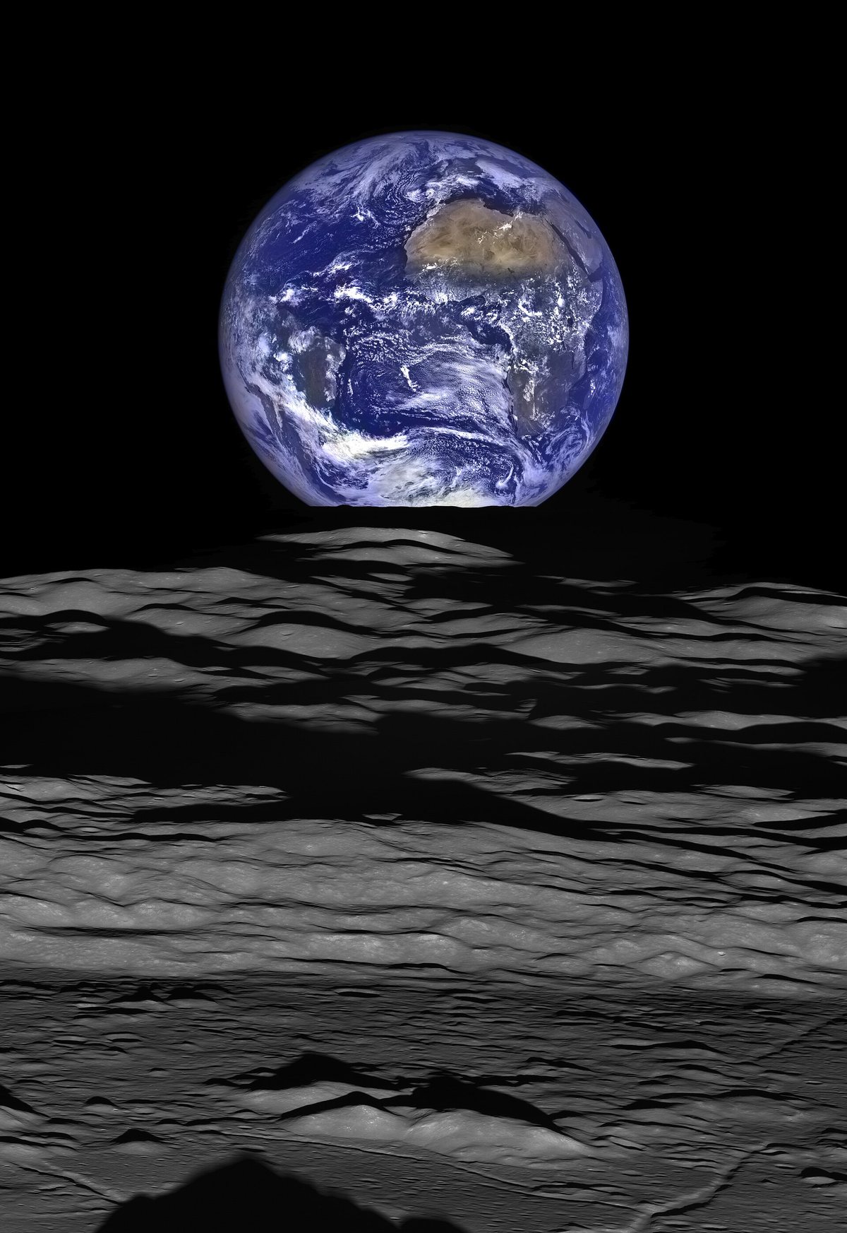 月面のクレーターの向こうに地球が昇る「地球の出」の写真