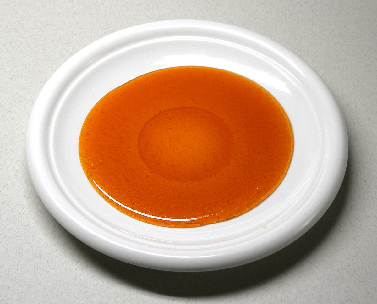 Melted, browned sugar (caramel) spread on a white plate