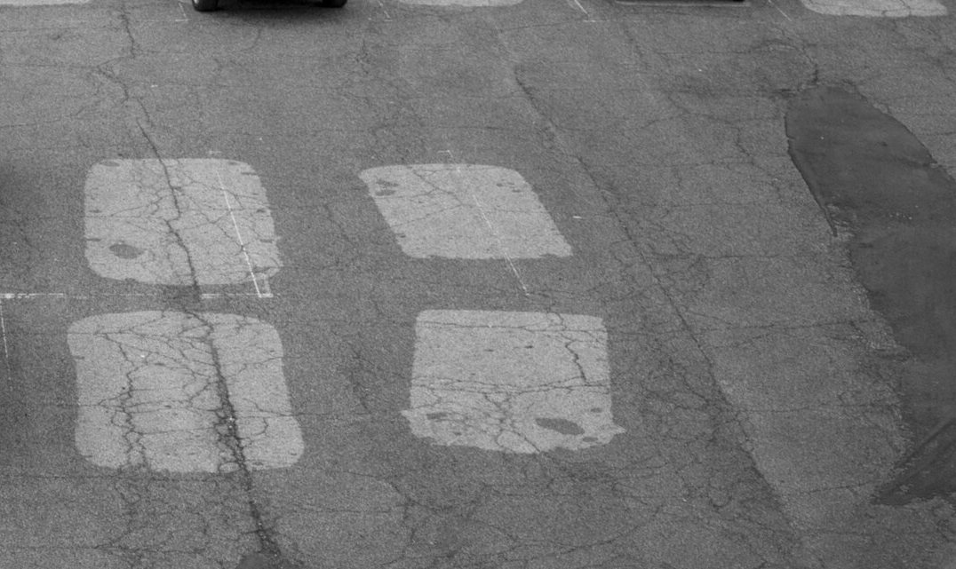 雨にぬれた駐車場に残る乾いた四角い跡