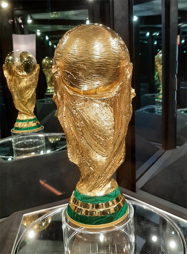 받침대에 초록색 띠가 있는 황금빛 FIFA 월드컵 트로피